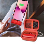 Open red case organizing a mini power bank and cable beside a charging phone