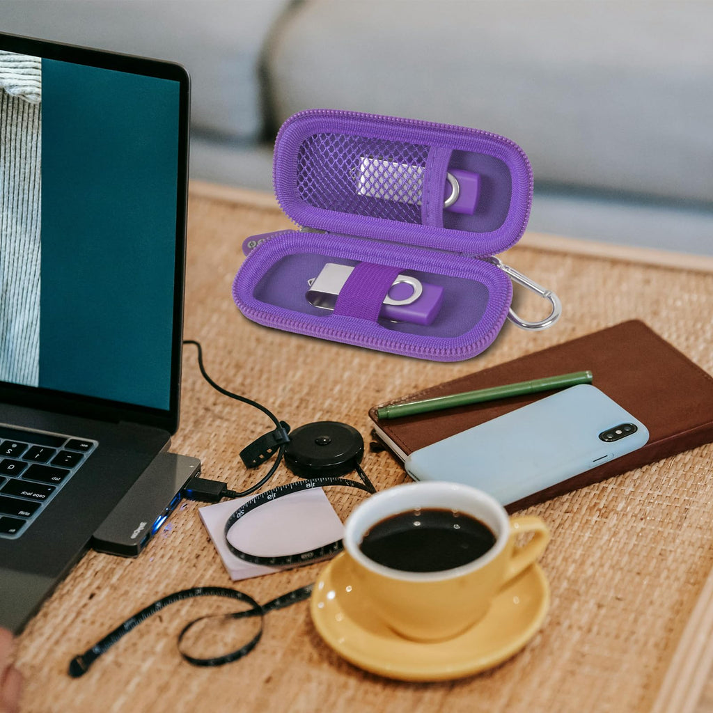 Purple USB flash drive and SD card storage case open on a desk with electronics accessories