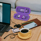 Purple USB flash drive and SD card storage case open on a desk with electronics accessories