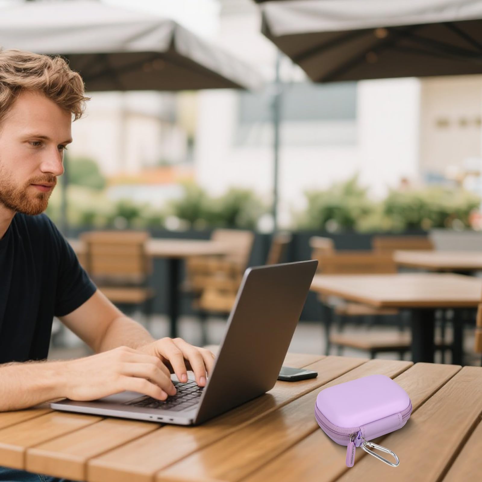 Lavender portable SSD case beside a laptop at an outdoor cafe