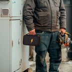 Technician carrying the black and yellow multimeter case by its top handle