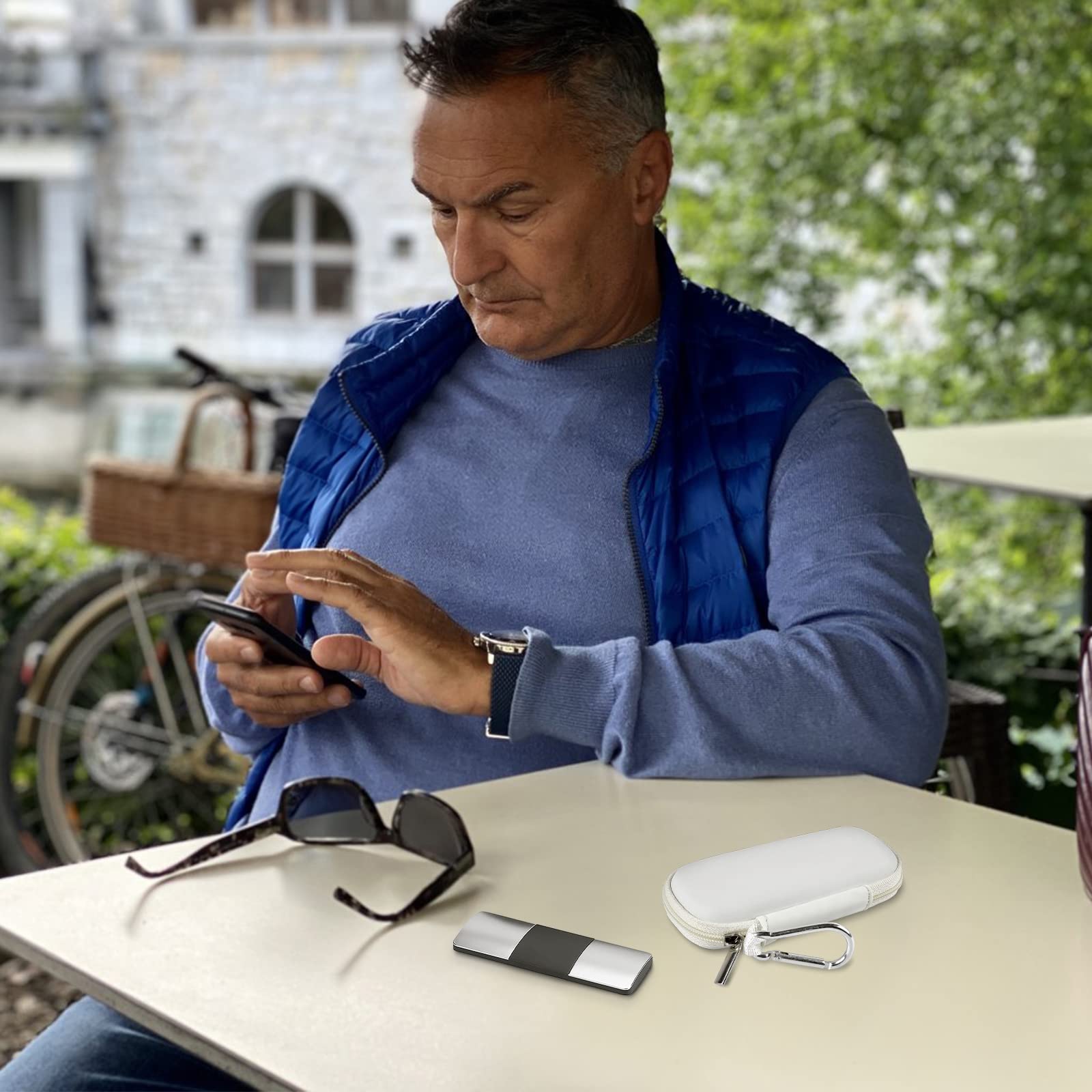 Man using a KardiaMobile device beside the open white travel case