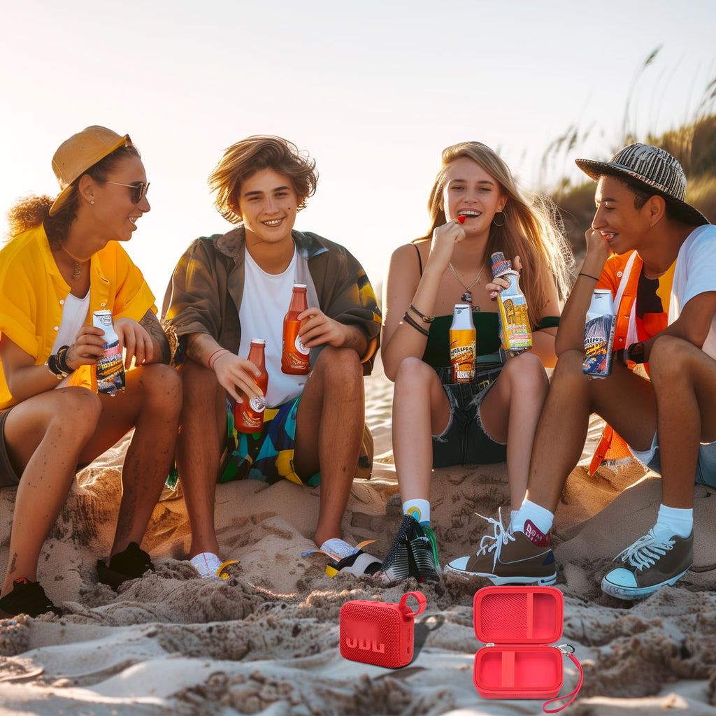 Friends using a JBL Go speaker with the open red travel case at the beach