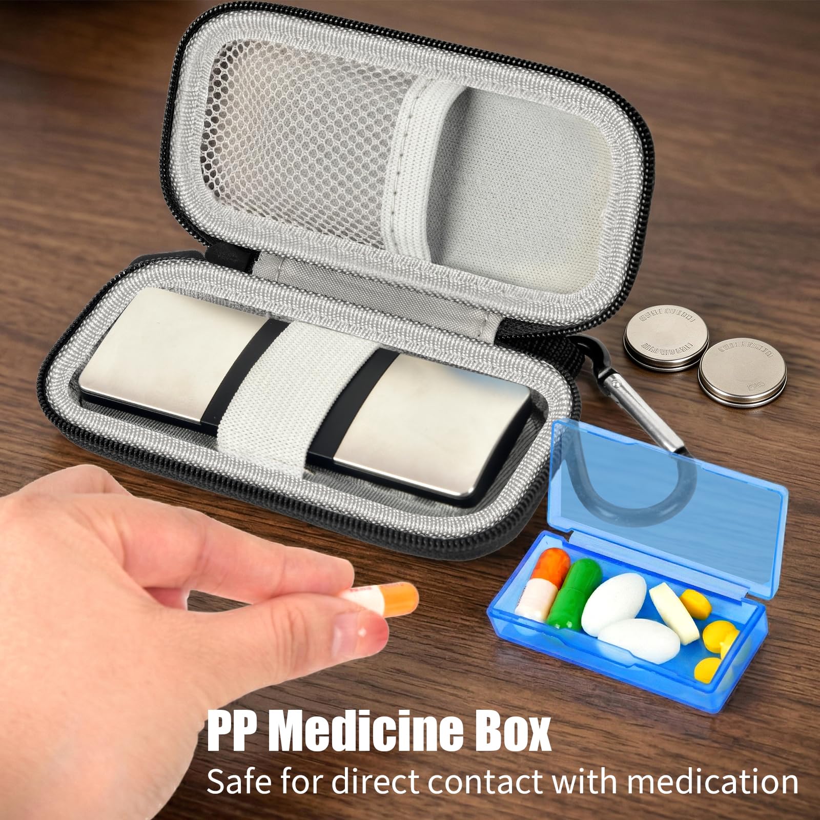 Open black organizer storing a KardiaMobile device, medicine box, and small accessories