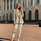 Woman carrying the beige headphone case by its wrist strap while traveling