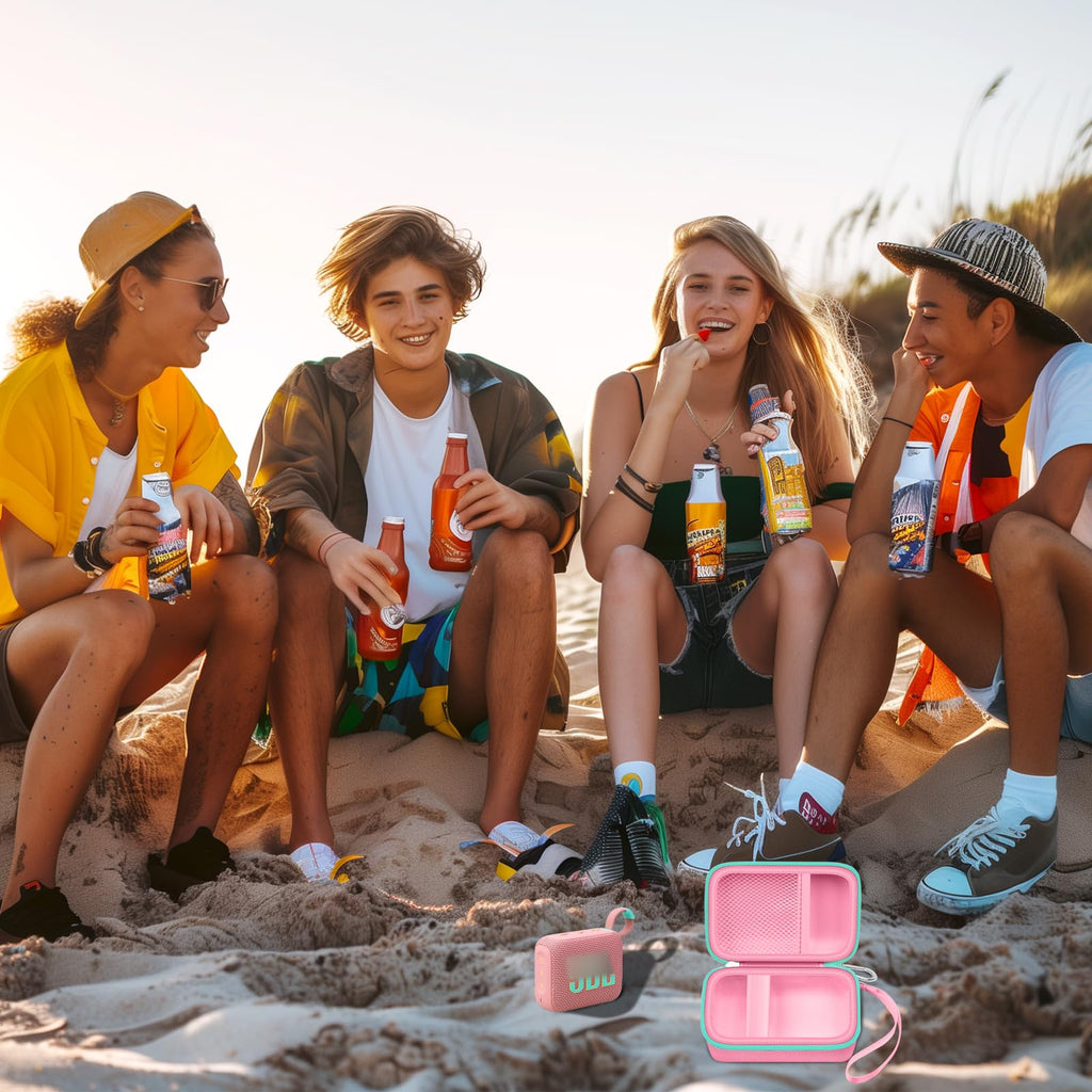 Friends using a JBL Go speaker with the open pink and mint green travel case at the beach