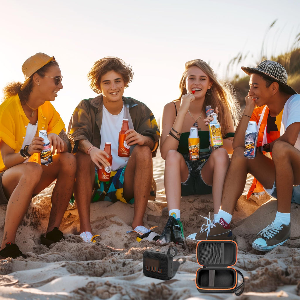 Friends using a JBL Go speaker with the open black and orange travel case at the beach