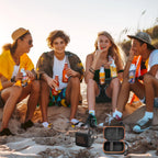 Friends using a JBL Go speaker with the open black and orange travel case at the beach
