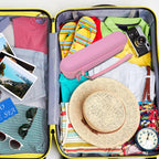 Pink slim electric toothbrush case packed inside a suitcase